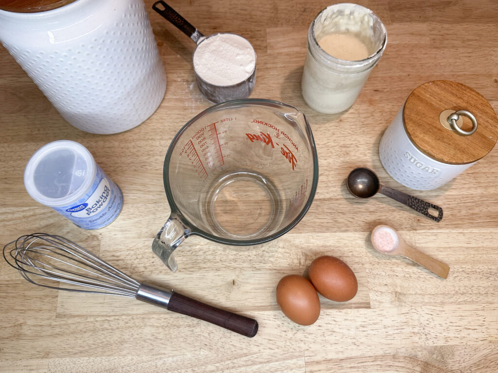 Ingredients to make sourdough discard funnel cakes: flour, salt, sugar, baking powder, sourdough discard, eggs, vanilla, and milk.